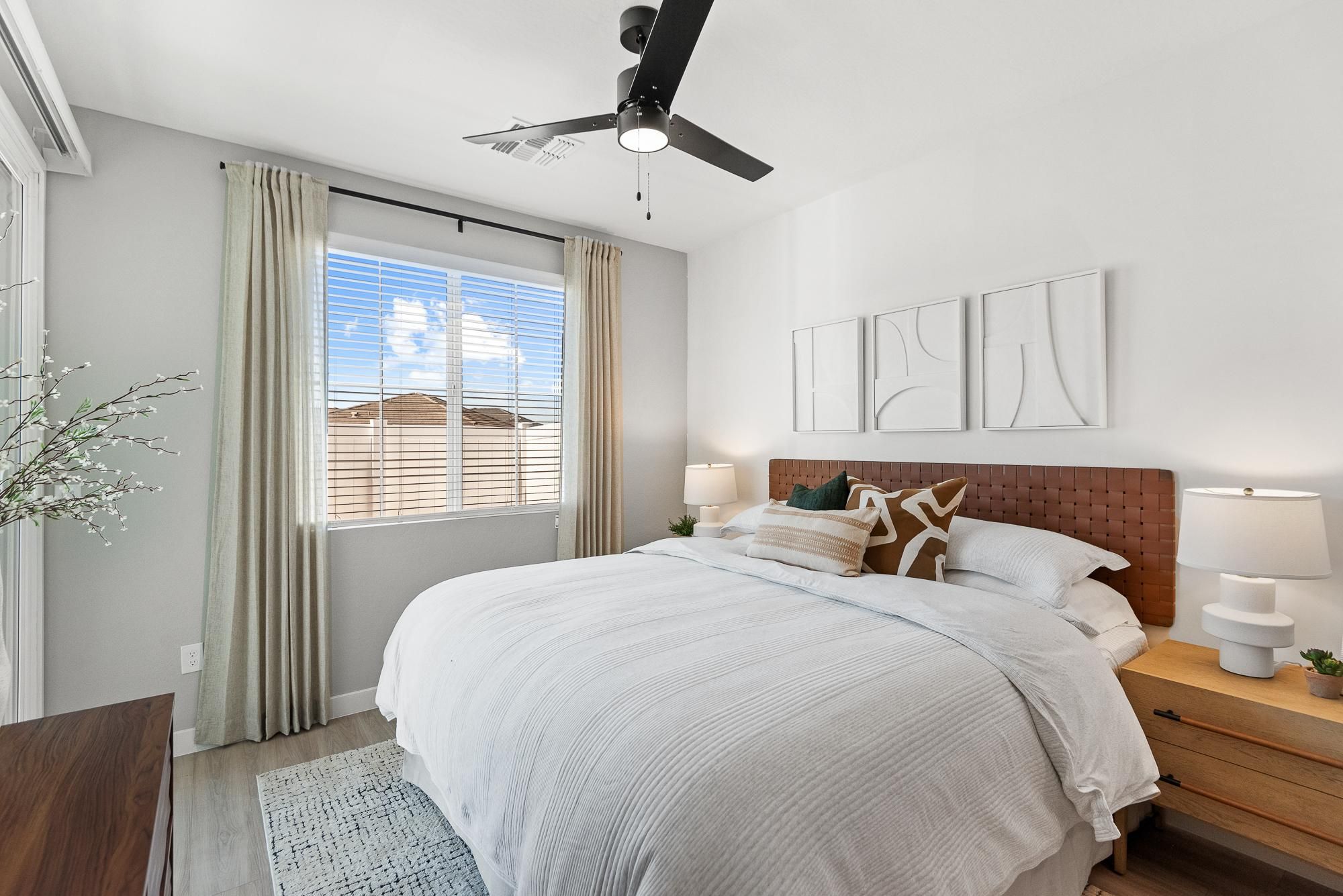 Verge Apache Junction modern kitchen with wood cabinets, stainless steel appliances, white countertops, and a potted plant on the island.