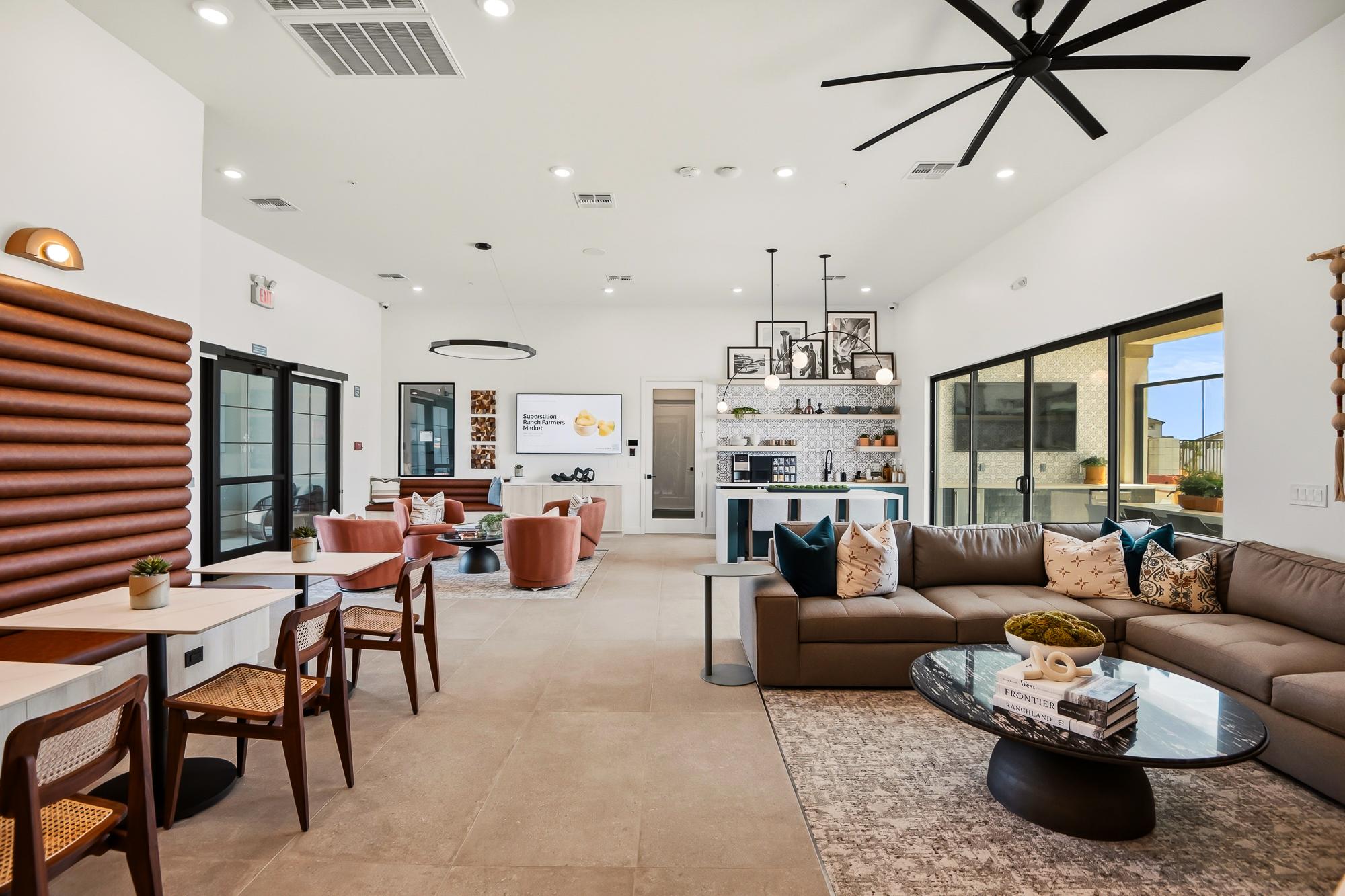 Modern open-concept lounge with a kitchen, dining area, large sectional sofa, and stylish decor.